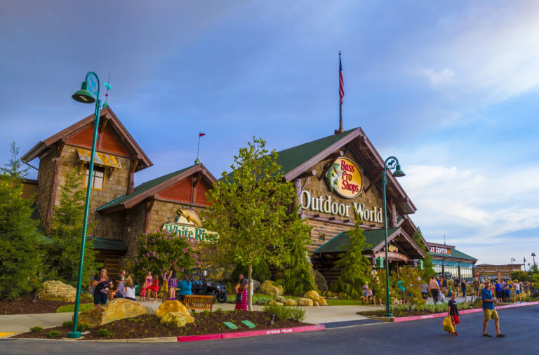 Exterior of Bass Pro Shops entrance with customers entering and exiting