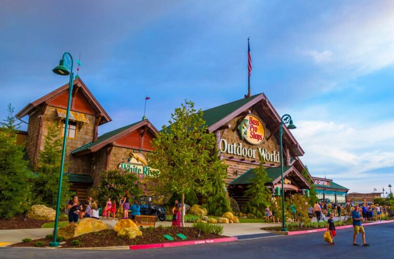 Exterior of Bass Pro Shops entrance with customers entering and exiting