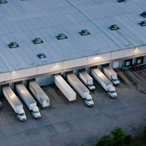 Several semi-trucks backed up to doors at a distribution facility