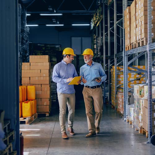 Two men walking in a warehouse facility