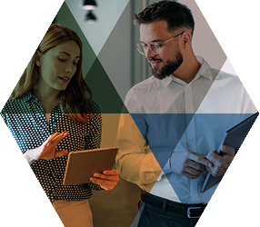 Professional man and woman walking and talking, looking at a digital tablet in her hand