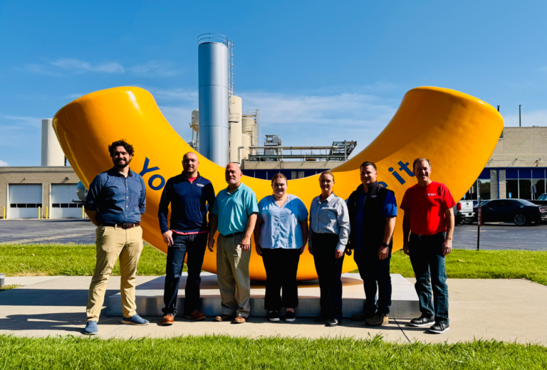 Group of people standing in front of a big noodle at Kraft manufacturing plant in Springfield, Missouri